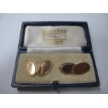 A Pair of 9ct Gold Gent's Cufflinks, each oval panel with patterned detail, on chain connections, in
