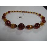 A Modern Amber Coloured Bead Necklace, of graduated design, to screw clasp.