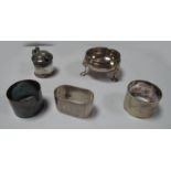 A Hallmarked Silver Salt, raised on three hoof capped feet; three hallmarked silver napkin rings,