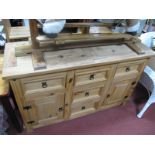 A Lightwood Sideboard, of five drawers and two cupboard drawers.