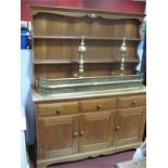 A Pine Dresser, with planked rack over three drawers and cupboard doors.