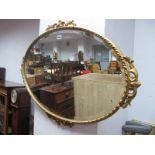 An Oval Bevelled Gilt Wall Mirror, two similar circular examples and another mirror. (4)