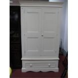 A Painted Pine Wardrobe, with twin panelled cupboard doors, over a long drawer, on a plinth base.