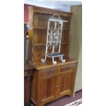 A Stained Pine Dresser, shaped apron piece over two shelves, drawers and cupboards below.