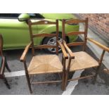 A Pair of Early XX Century Beech Carver Chairs, with shaped ladder backs and rounded seats.