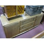 An Ercol Light Ash Sideboard, with cupboards, flanking three drawers, 155.5cm wide (top stained).