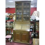 An Oak Bureau Bookcase, with lattice glazed doors, fall front, fitted interior and cupboard doors.