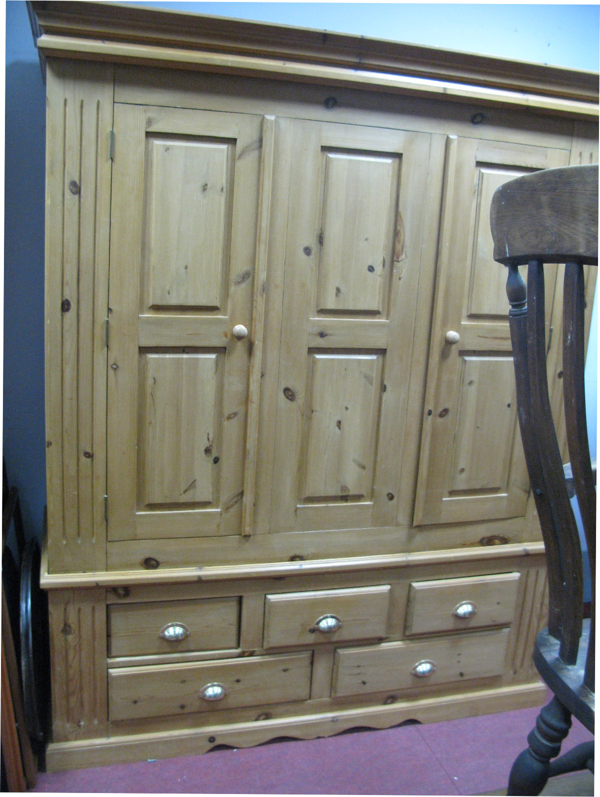 A Pine Three Door Wardrobe, with stepped pediment, five drawers to base, 165cm wide.