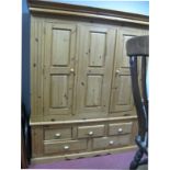 A Pine Three Door Wardrobe, with stepped pediment, five drawers to base, 165cm wide.