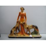 An Art Deco Plaster Figure of a Lady with Dog, either side on rectangular base.