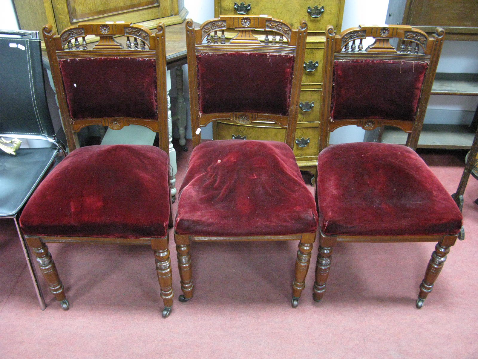 Three Edwardian Walnut Salon Chairs, each with pokerwork, carved top rail, spindle supports on