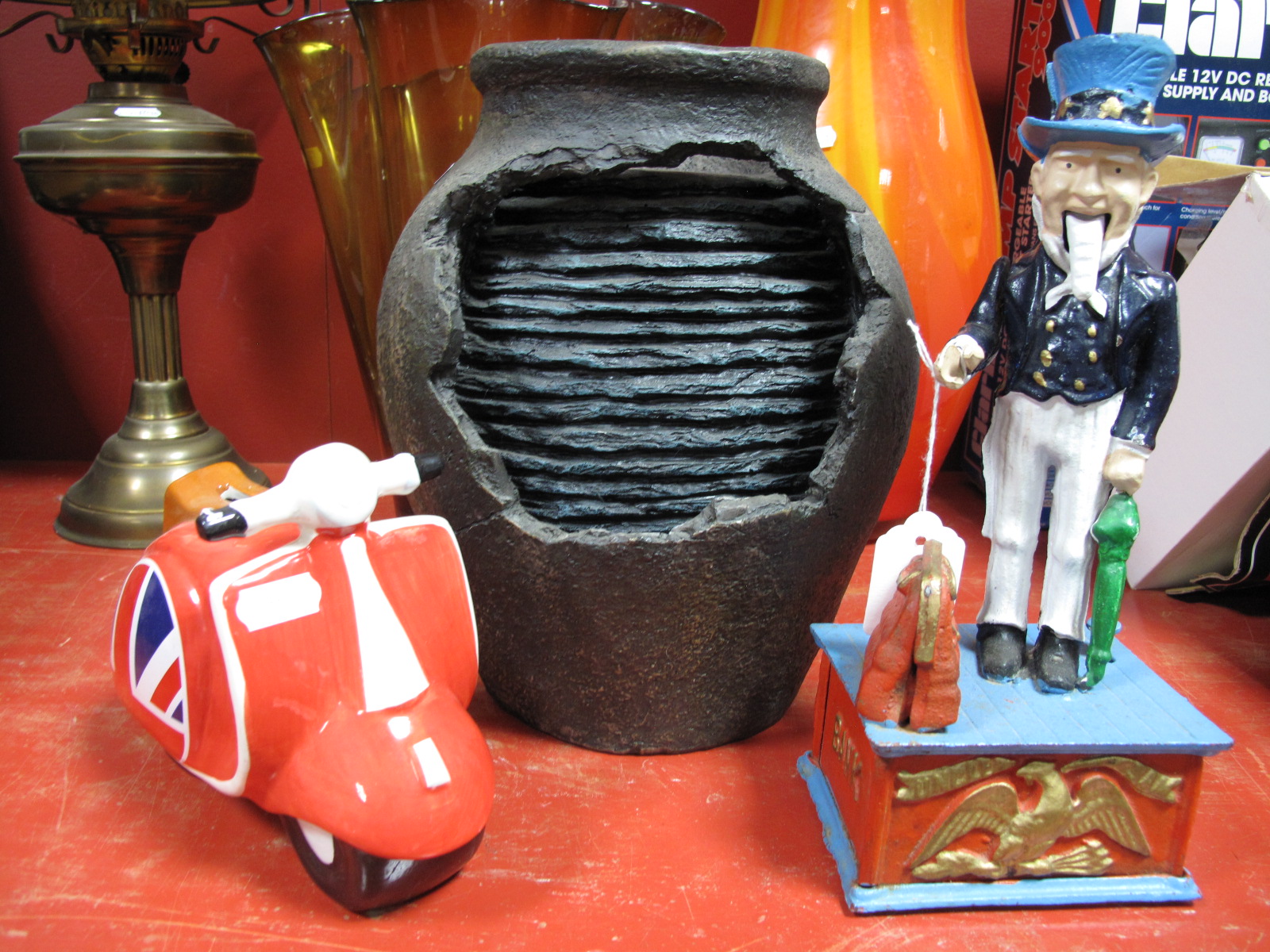 A Reproduction American 'Uncle Sam' Cast Iron Money Bank, a pottery scooter money bank and a vase