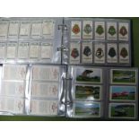 A Collection of Trade and Cigarette Cards, in two albums, noted Kensitas silks.