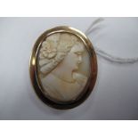 An Oval Shell Carved Cameo Brooch, depicting female profile, collet set.
