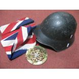 A Post War European Steel military Helmet, a union jack and four mounted cap badges.