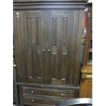 A Hardwood Wardrobe, with panelled doors, two long drawers on stile feet.