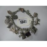 A Curb Link Charm Bracelet Suspending Numerous Novelty Charm Pendants, including windmill, carriage,