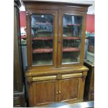 A XIX Century Mahogany Bookcase, the top with stepped cornice and glazed doors, the base with two