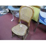 A XIX Century Nursing Chair, hooped back, caned back panel and seat, turned legs on rockers.