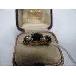 A 9ct Gold and Garnet Dress Ring set with Seed Pearls, comprising three graduated garnet stones claw