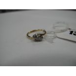 A Three Stone Diamond Ring, the graduated old cut stone rubover set between crossover shoulders,