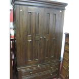 A Hardwood Wardrobe, with panelled doors, two long drawers on stile feet.