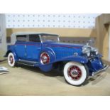 A Franklin Mint Model of a 1932 Cadillac, in blue, appears complete, boxed with paperwork.
