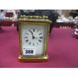 A Brass Carriage Clock, with black Roman numerals, to white enamel dial, swing handle 7.5cm wide