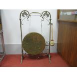 A Brass Dinner Gong, circa 1900, suspended in wirework frame having scroll decoration,feet and