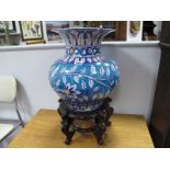 Persian Pottery Vase, with leaf decoration to turquoise bulbous body (damaged) and wooden stand,