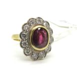 A Large 18ct Gold Ruby and Diamond Cluster Ring, oval collet rubover set to the centre with an (