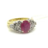 An 18ct Gold Ruby and Diamond Set Ring, oval four claw set to the centre with an (8x6mm) oval