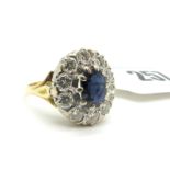 An 18ct Gold Sapphire and Diamond Cluster Ring, the oval cut sapphire claw set within border of