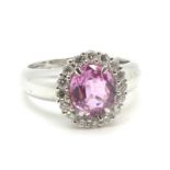 A Pink Sapphire and Diamond Set Cluster Ring, the central claw set stone within uniform surround