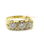 An 18ct Gold Three Stone Diamond Ring, of graduated design with claw set highlights, within scroll