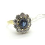 A Sapphire and Diamond Cluster Ring, oval claw set to the centre, within border of ten uniform