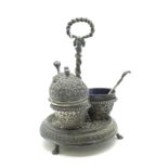 Oomersi Mawji; An Indian Cruet Stand, of circular form detailed with leaf scrolls and serpent detail