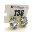 A Pair of Large Single Stone Earrings, each oval four claw set, on Continental hinged back fittings,