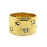 An 18ct Gold Wide Diamond Set Band, of uniform textured design, later star set with uniform