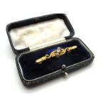 A Three Stone Diamond Set Bar Brooch, the graduated old cut stones offset between textured leaf