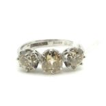 A Three Stone Diamond Ring, the old cut stones claw set, between knife edge shoulders, stamped "18ct