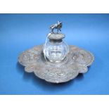 A Highly Decorative Desk Inkwell on Stand, the shaped stand profusely detailed in relief with