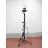 An Early XX Century Floor Standing Wrought Iron and Copper Oil Lamp, with brass reservoir, glass