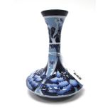 A Moorcroft Pottery Vase, of trumpet form, painted in the 'Flori' pattern against a dark blue
