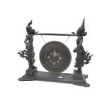 A Late XIX Century Siamese Dinner Gong, elaborately carved with two figures in traditional costume