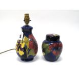 A Moorcroft Pottery Table Lamp, of ovoid form, painted in the 'Hibiscus' pattern against a dark blue