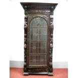 A XIX Century Carved Oak Display Cabinet, with stepped pediment, frieze carved with an animal head