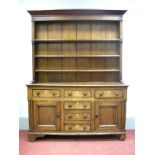 An Early XIX Century Oak and Mahogany Dresser, the pine back with three shelves and half columns,