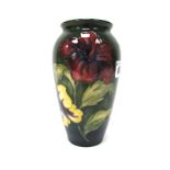 A Moorcroft Pottery Vase, of ovoid form, painted in the 'Hibiscus' pattern against a green ground,