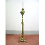 An Early XX Century Floor Standing Brass Oil Lamp, the central column with scrollwork and raised